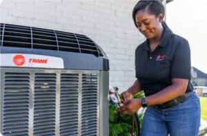 trane-technician-inspects-ac-1 trane heat pump and technician